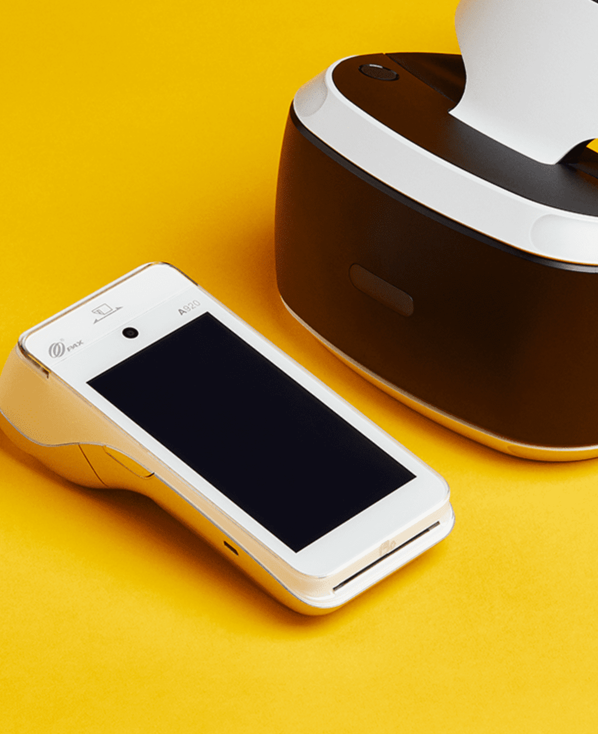 Terminal de paiement intelligent blanc et casque de réalité virtuelle sur fond jaune moderne.