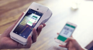 Paiement mobile avec code QR scanné sur terminal POS moderne en commerce.