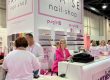 Stand FRASE Nail Shop moderne rose et blanc présentant vernis et produits de manucure au salon.