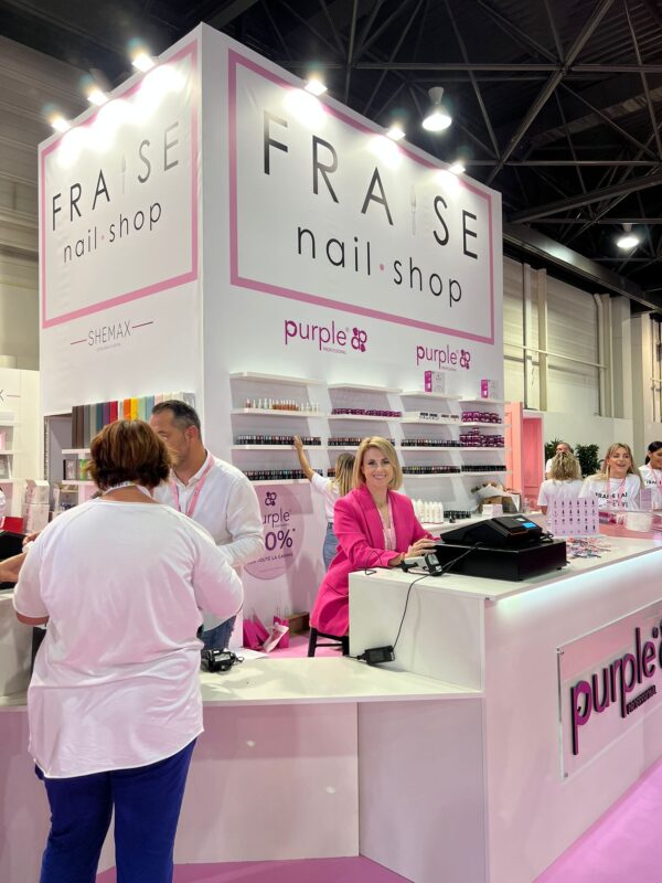 Stand FRASE Nail Shop moderne rose et blanc présentant vernis et produits de manucure au salon.