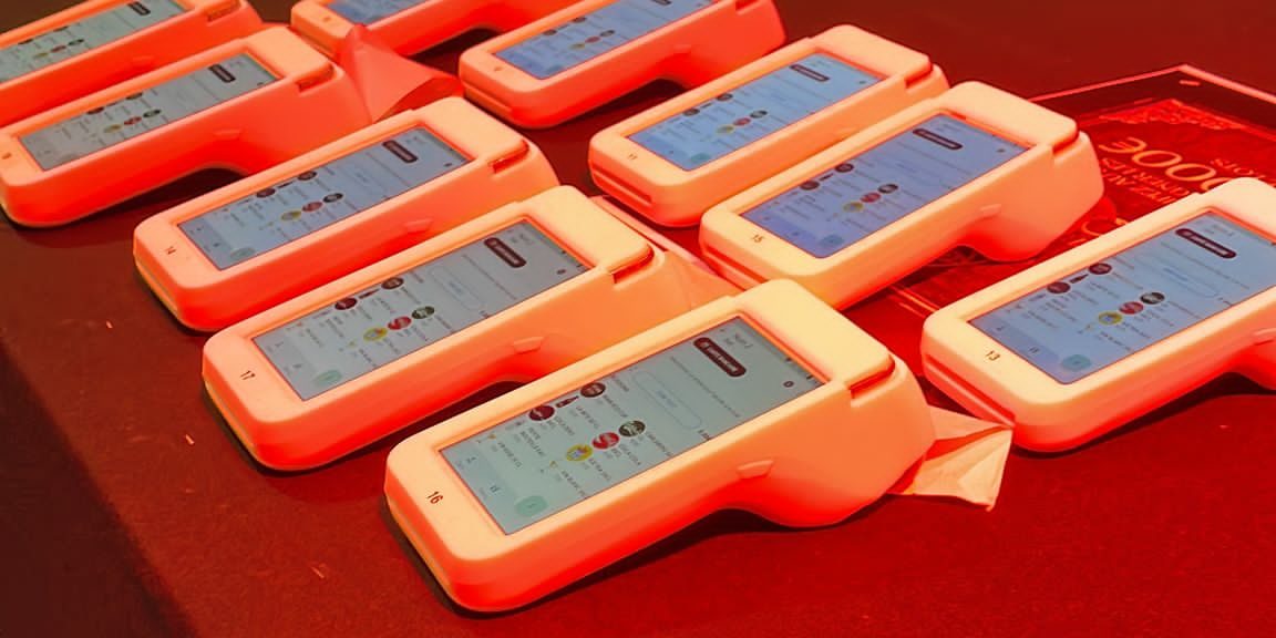 Terminaux électroniques alignés sur table rouge prêts pour un événement technologique à Grenoble.