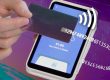 Paiement sans contact avec carte bancaire noire et iPhone sur fond numérique futuriste.